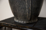 Recycled tire rubber basket detail showing dark striated and pebble textures with white stitching.