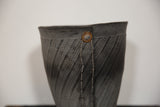 Textured dark grey recycled tire rubber basket with diagonal ridges and rustic metal rivet.