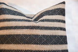 Pillow with textured natural fabric and onyx black geometric stripes.