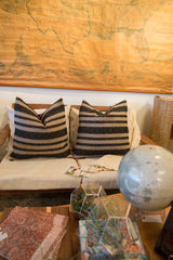 Two reclaimed remnant onyx black and natural pillows, showcasing woven stripe detail.