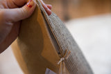Pillow zipper detail showing black jute woven fabric and soft tan faux suede.