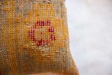 Hand-woven texture detail of the antique rug fragment pillow, showing ruby red and golden patterns.