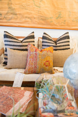 Reclaimed antique Turkish rug fragment pillow, orange, yellow, and red geometric patterns.