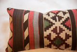 Antique Kilim fragment pillow showing woven tribal patterns in deep reds, cream, and brown.