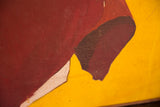 Close-up showing cracked texture on the vintage painting's red and yellow abstract design.