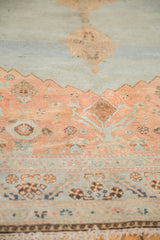 Detailed view of distressed Malayer carpet with pale terra cotta and slate blue intricate motifs.