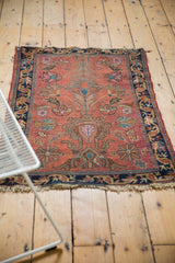 Tattered bottom fringe and navy border of vintage hand-knotted Lilihan rug with floral motifs.