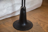 Industrial metal base of vintage end table with embossed text and connecting bolts.