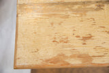 Faded soft sage cream paint revealing natural wood texture on vintage end table.