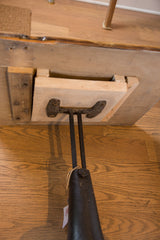 Reclaimed wood tabletop underside, showing industrial metal base connection and added wooden support.