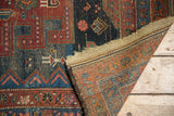 Detail of hand-knotted antique Hamadan rug showing cherry red and navy geometric pile and woven back.