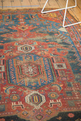 Antique Hamadan rug close-up: geometric navy medallion and cherry red field motifs showing wear.
