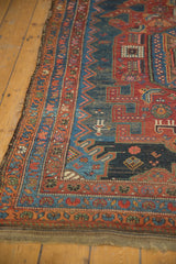 Time-softened pile and secured side of an antique Kurdish Hamadan rug with ornate borders.