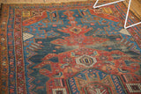 Antique Hamadan rug: asymmetric medallion, deep navy, cherry red, and visible pile wear.