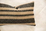 Natural and onyx black pillow textile with intricate geometric woven pattern.