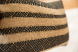 Onyx black and natural pillow, showing textured geometric pattern within horizontal stripes.