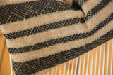 Woven texture detail of onyx black geometric stripes on natural remnant pillow.