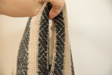 Pillow side detail showing open zipper with onyx black and natural zigzag woven pattern.