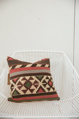 One-of-a-kind handmade antique kilim pillow featuring bold geometric patterns in brown, red, and cream.