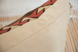 Detail of reclaimed kilim pillow: geometric red, brown pattern meeting soft beige faux-suede.