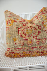 Close-up of the antique Turkish rug fragment pillow's bottom edge, highlighting its coarse geometric pattern.
