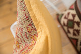 Woven antique rug fragment pillow with red and yellow pattern, featuring ribbed mustard yellow backing.