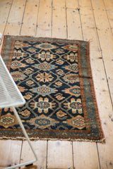 Vintage Lilihan rug's lower end, revealing the chained lattice, floral cross-sections, and tattered edge.