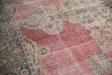 Even wear across the knot heads on the faded raspberry pink field of an antique Persian carpet.