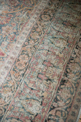 Time-softened pile on an antique Kermanshah rug showing distressed texture and visible foundation.