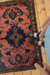 Vintage Lilihan rug's primitive navy blue medallion and dramatic scrolling leaves on a blush field.