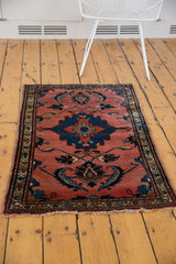 Tattered fringe and ornate border on a vintage Lilihan rug's dark rose field.