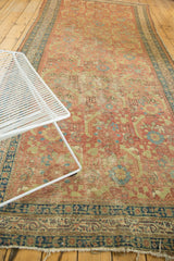 Angled view of an antique Persian runner's large-scale herati design in rust and celadon.