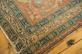 Detailed corner view of a Northwest Persian antique rug showing its navy blue border and time-softened wear.
