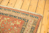 Light tatter on the hand-finished edge of an antique Northwest Persian runner with a navy and rust border.