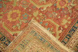 A folded corner on an antique Persian runner reveals the reverse hand-knotted weave and tattered selvedge.