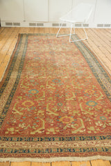 An antique Persian runner viewed at length, showing the scale of its oversized Herati pattern.