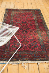 Raspberry red field of a vintage Lilihan rug with floral vinery and mostly even wear.