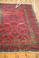 Raspberry red Lilihan rug's floral palmette field, with visible wear and tattered fringe.