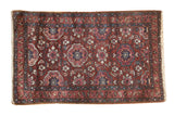 Vintage Lilihan rug with a repeating floral medallion lattice in cherry red, navy blue, and fuchsia.