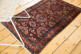 Angled view of a vintage Lilihan rug showing its repeating lattice medallions and vivid gem tones.
