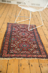 Angled view of a vintage Lilihan rug with floral medallions in cherry red, fuchsia, and teal.