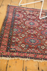 Corner of a vintage Lilihan rug with a detailed fuchsia and navy blue floral border.