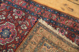 The fine hand-knotted weave and secure ivory fringe of a vintage Persian Lilihan rug corner.