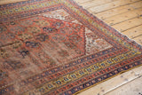 Antique Qashqai rug corner: rare saffron gold border, terra cotta boteh motifs, wear along selvage.