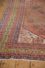 Antique Qashqai rug's rare saffron gold border, pale madder red field with shadow boteh, and knot wear.