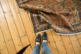 Distressed Malayer rug edge, faded pile, visible potted plant motifs, seafoam green, terra cotta.
