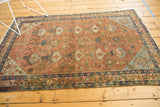 Distressed pile of the vintage Malayer rug, showing potted plant motifs in pale terra cotta.
