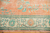 Distressed Oushak border shows arts and crafts motifs, pale tangerine, mint green, antique ivory.