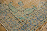 Distressed Oushak rug corner, showing paisley boteh, pale blue, mint, peach palette, and even pile wear.