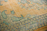 Faded pale orange distressed Oushak rug with mint green paisley corner and royal blue border.